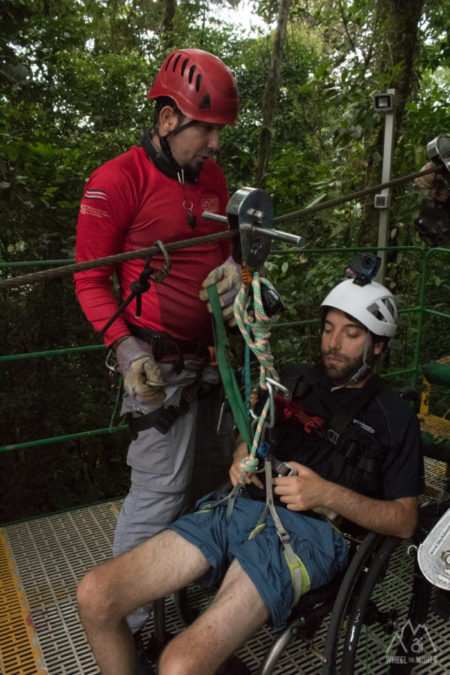 Man in wheelchair with harness and attached to canopy cable